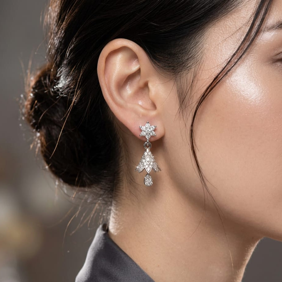 A close-up of a woman's ear wearing a Silver Jhumki Earrings for Women | Elegant Traditional Jewelry ✨ with clear gemstones, set against a softly blurred neutral background.